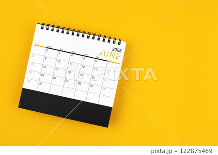 June 2025 desk calendar on yellow background, position with copy space. 122875469