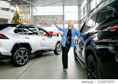 Customer taking selfie with new car in dealership Customer taking selfie with new car in dealership 122875857