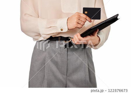 woman in white blouse and grey pants using credit card and digital tablet on white background woman in white blouse and grey pants using credit card and digital tablet on white background 122876673