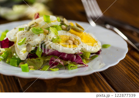Appetizing egg dish in a plate on a wooden table Appetizing egg dish in a plate on a wooden table 122877339