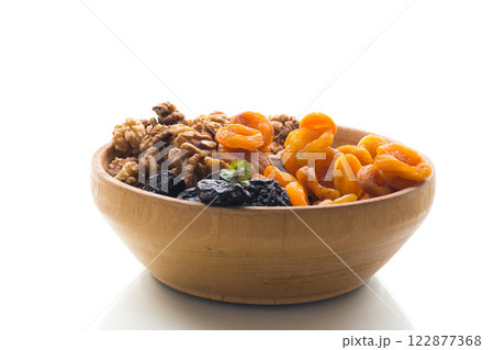 Prunes, dried apricots and nuts in a wooden bowl on a white background 122877368