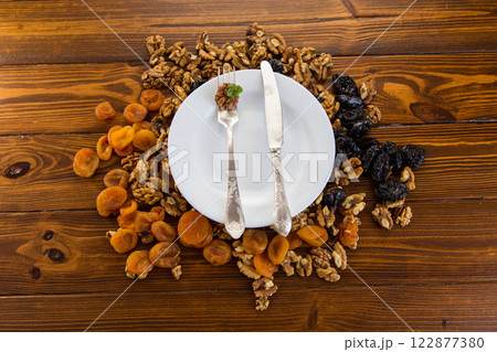 Clean empty plate with healthy dried fruits and nuts with antique cutlery Clean empty plate with healthy dried fruits and nuts with antique cutlery 122877380