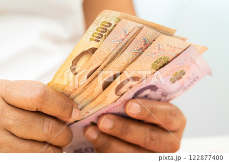 Asian woman holding Thai banknotes money, economy finance exchange trade investment. 122877400