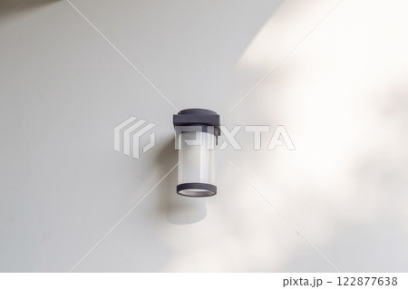 Outdoor cylinder lamp with tree leaves shadow on concrete wall Outdoor cylinder lamp with tree leaves shadow on concrete wall 122877638