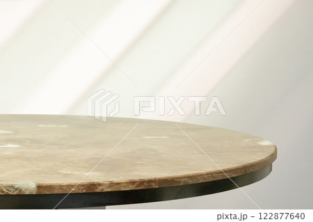 Round marble table top with abstract shadow drop on white wall background for mockup product display Round marble table top with abstract shadow drop on white wall background for mockup product display 122877640