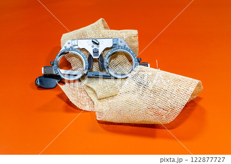 optical device for vision testing on a brown cloth with a orange surface optical device for vision testing on a brown cloth with a orange surface 122877727