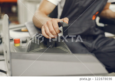Industrial worker indoors in factory. Young technician with orange hard hat. 122878036