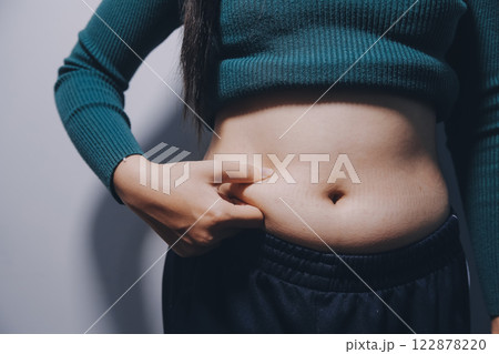 Asian Woman Pinching Her Belly Fat With Left Hand 122878220
