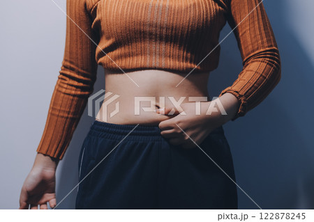 Asian Woman Pinching Her Belly Fat With Left Hand Asian Woman Pinching Her Belly Fat With Left Hand 122878245