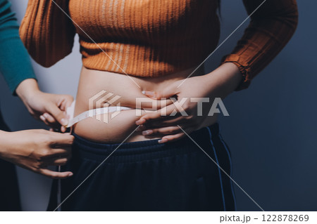 Asian Woman Pinching Her Belly Fat With Left Hand Asian Woman Pinching Her Belly Fat With Left Hand 122878269