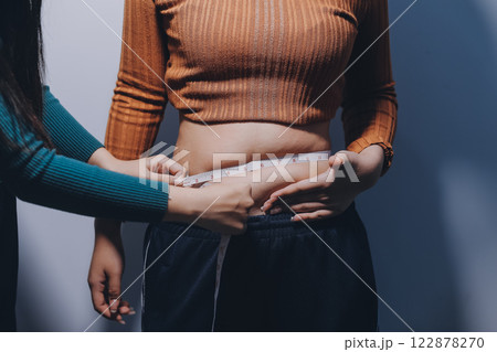 Asian Woman Pinching Her Belly Fat With Left Hand Asian Woman Pinching Her Belly Fat With Left Hand 122878270