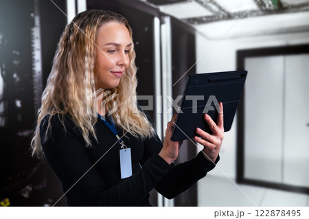 Young professional consultant using a tablet in a modern data center environment 122878495