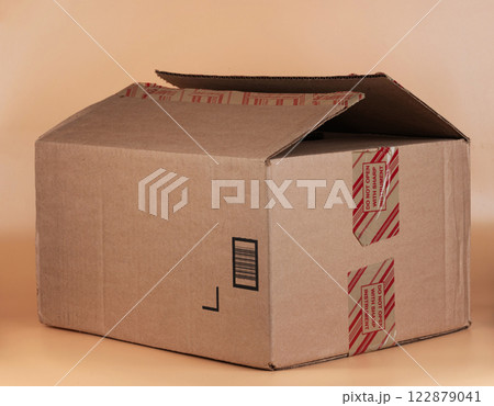 Cardboard box with opened flap for packaging and shipping items indoors Cardboard box with opened flap for packaging and shipping items indoors 122879041