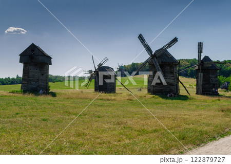 Old windmill on blue sky background Old windmill on blue sky background 122879727