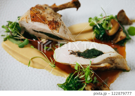 Indulge in our Gourmet Stuffed Chicken Breast, perfectly paired with a flavorful Herb Sauce 122879777