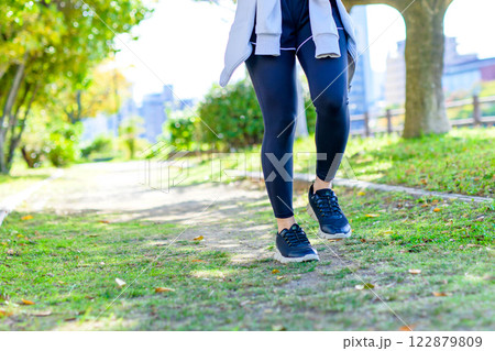 木漏れ日の道をジョギングするかっこいい女性　歩く　ダイエット　エクササイズ　運動　トリミングアップ 122879809