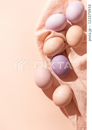 Easter background with colorful pastel eggs on linen napkin. Trendy Easter card in minimalistic style with copy space. 122879938