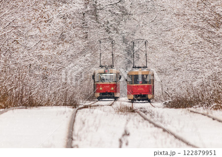 An old tram moving through a winter forest 122879951