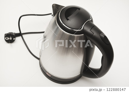 Electric kettle on a white background. A metal teapot with a black handle. Electric kettle on a white background. A metal teapot with a black handle. 122880147