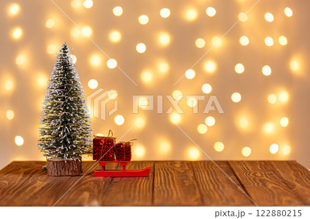 christmas tree, clock, sledge, snowman, candles, gifts on a wooden background and lights background christmas tree, clock, sledge, snowman, candles, gifts on a wooden background and lights background 122880215