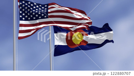 Colorado and US flags waving in the wind on a clear day 122880707