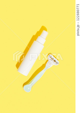 Minimalist elegance: RazorRazor and bottle of cream against a yellow backdrop with dramatic shadows Minimalist elegance: RazorRazor and bottle of cream against a yellow backdrop with dramatic shadows 122880771