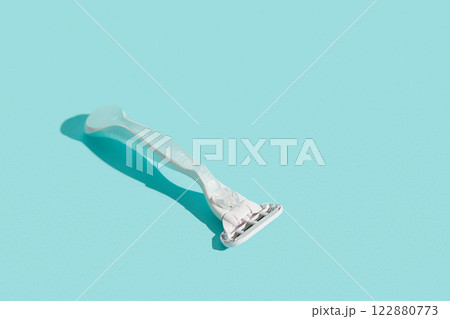 Minimalist elegance: Razor in sharp relief against a bold blue backdrop with dramatic shadows 122880773