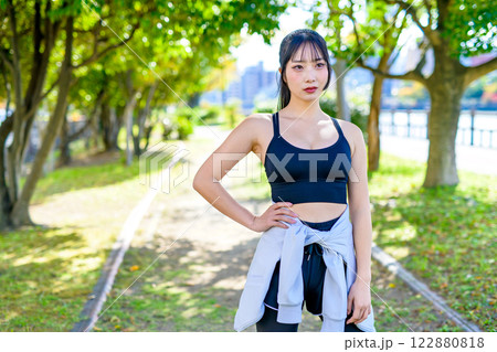 木漏れ日の道をジョギングするかっこいい女性　歩く　ダイエット　エクササイズ　運動　 122880818