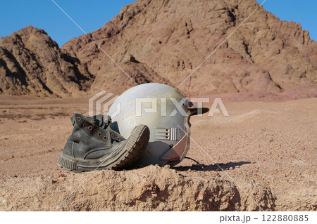 Old boot and motorcycle helmet in Sinai desert Old boot and motorcycle helmet in Sinai desert 122880885