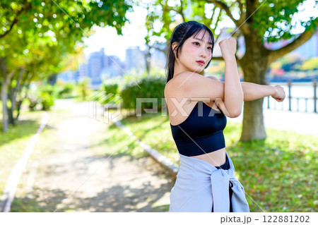 木漏れ日の道で肩の肩甲骨ストレッチをするかっこいい女性 準備運動 エクササイズ トリミングアップ 木漏れ日の道で肩の肩甲骨ストレッチをするかっこいい女性 準備運動 エクササイズ トリミングアップ 122881202