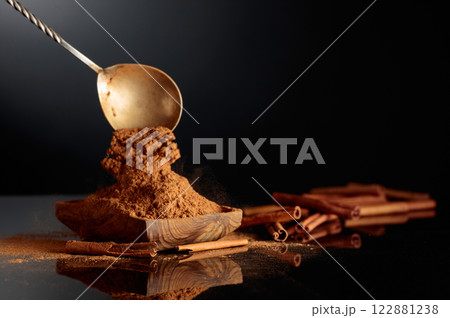 Cinnamon powder is poured into a wooden dish. Cinnamon powder is poured into a wooden dish. 122881238