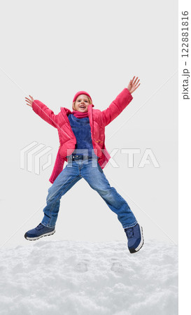 Girl dressed colorful winter clothes, mid-air with stretched limbs, delighted face, winter adventure captured in motion against white background. 122881816