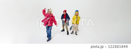 Banner. Group of children, throwing snowballs, playing joyfully, showing excitement and happiness of winter activities against white background. Banner. Group of children, throwing snowballs, playing joyfully, showing excitement and happiness of winter activities against white background. 122881849