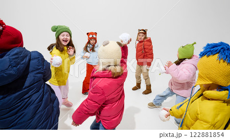 Group of children, laughing and playing, dressed warm winter outfits, throwing snowballs, having fun and energy-filled moment against white studio background. Group of children, laughing and playing, dressed warm winter outfits, throwing snowballs, having fun and energy-filled moment against white studio background. 122881854