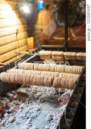 Trdelnik. Traditional dessert baked in an open fire wooden stake in Dresden Christmas Market. 122882487