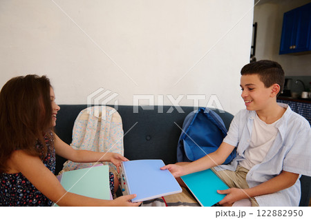 Children sharing colorful notebooks cheerfully 122882950