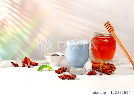 Blue lavender milk matcha latte with cinnamon, anise and honey spices on sunny table. Weight loss and alternative medicine concept, relaxing drink before bed and boosting immunity, Indian cuisine 122883694