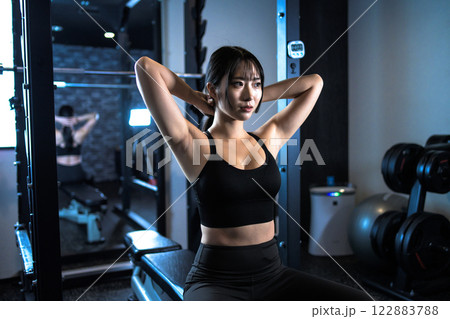ジムで体を鍛える髪を結ぶかっこいい女性　パワーラック　ベンチプレス　筋トレ女子　 122883788