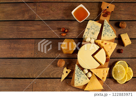 Assortment of different types of cheese, blue cheese, gorgonzola, roquefort, parmesan, mozzarella, maasdam with honey and nuts, healthy and natural food selection, cafe and menu advertising card 122883971