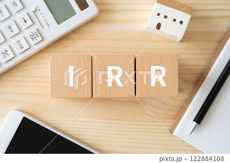 IRRと書かれたブロック、電卓、スマホ、建物の模型 IRRと書かれたブロック、電卓、スマホ、建物の模型 122884108