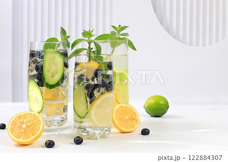 Detox water with lemon, cucumber, blueberry and mint flavors on a light background. A refreshing summer homemade lemonade cocktail. Fruit juice and ingredients, weight loss concept, Detox water with lemon, cucumber, blueberry and mint flavors on a light background. A refreshing summer homemade lemonade cocktail. Fruit juice and ingredients, weight loss concept, 122884307
