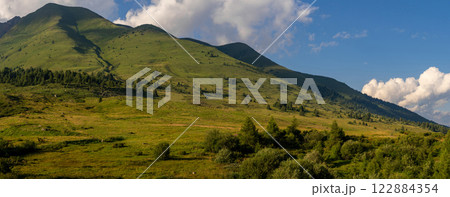 Panoramic View of Lush Green Hills Under Blue Sky 122884354