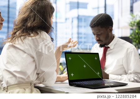 Job interview candidate interested in career advancement, talking with HR employee using isolated screen laptop. Man talking with recruiter checking his CV on mockup notebook to get hired 122885284