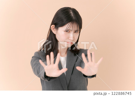 拒否のポーズをするスーツの女性 122886745