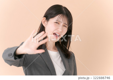 拒否のポーズをするスーツの女性 122886746