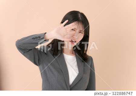 拒否のポーズをするスーツの女性 122886747
