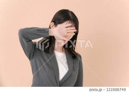 顔を隠すスーツの女性 顔を隠すスーツの女性 122886749