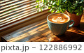 Morning coffee with latte art on a wooden table next to a potted plant. Perfect for promoting a cafe or creating a relaxing atmosphere on social media. It gives a feeling of warmth start to the day. 122886992