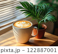 Morning coffee with latte art on a wooden table next to a potted plant. Perfect for promoting a cafe or creating a relaxing atmosphere on social media. It gives a feeling of warmth start to the day. 122887001