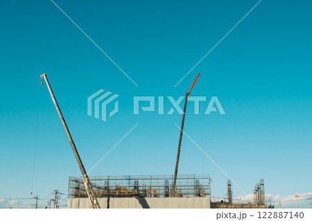 青空に伸びるクレーンとビル建設の足場 フィルム調 青空に伸びるクレーンとビル建設の足場 フィルム調 122887140